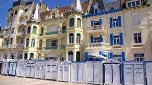 Une rangée de bâtiments de style européen traditionnel, dotés de balcons et de volets, qui font probablement partie d’un hôtel ou d’un complexe résidentiel.