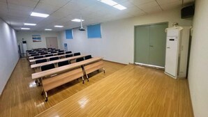 A classroom with rows of wooden desks and chairs, a projector, and a whiteboard. - Jinjiang Inn (Wuhan Lingjiaohu Wanda) (Wuhan)