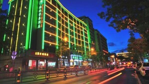 A hotel with a grid of windows and a green neon sign. - Greentree Inn Haikou City Wuzhishan Road (Haikou)