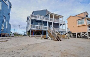 Situated on sandy terrain, this beachfront property offers a multi-level building with a spacious balcony on the ground floor.