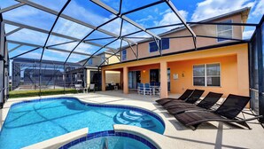 A swimming pool with lounge chairs and a covered patio area. - Dreams come true (Kissimmee)