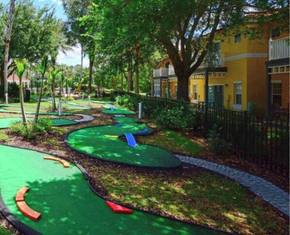 A golf course with green fairways, sand bunkers, and a water hazard.