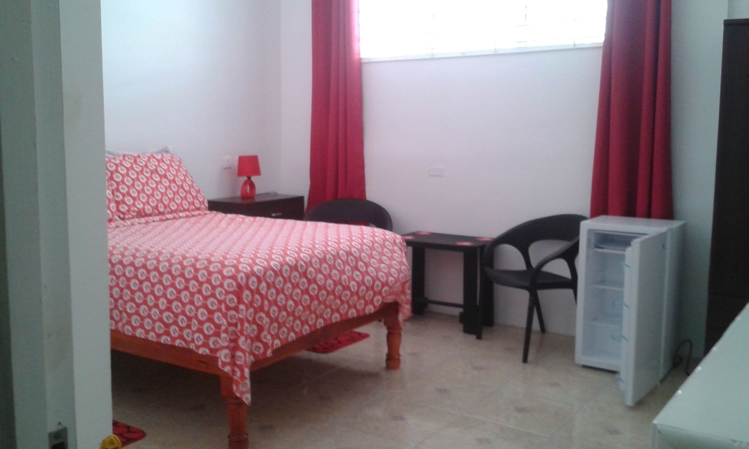 Un dormitorio con cama, escritorio, silla y radiador.