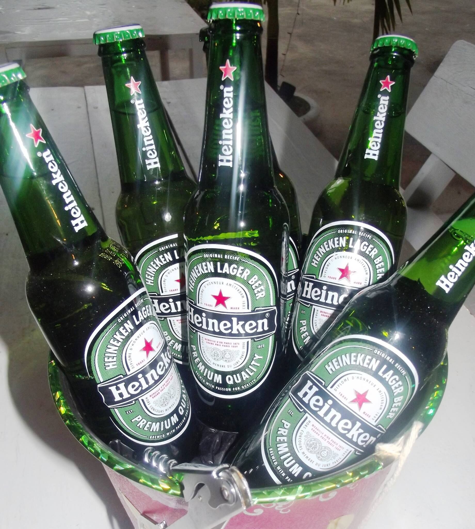 Heineken Bierflaschen in einem Metallbehälter.
