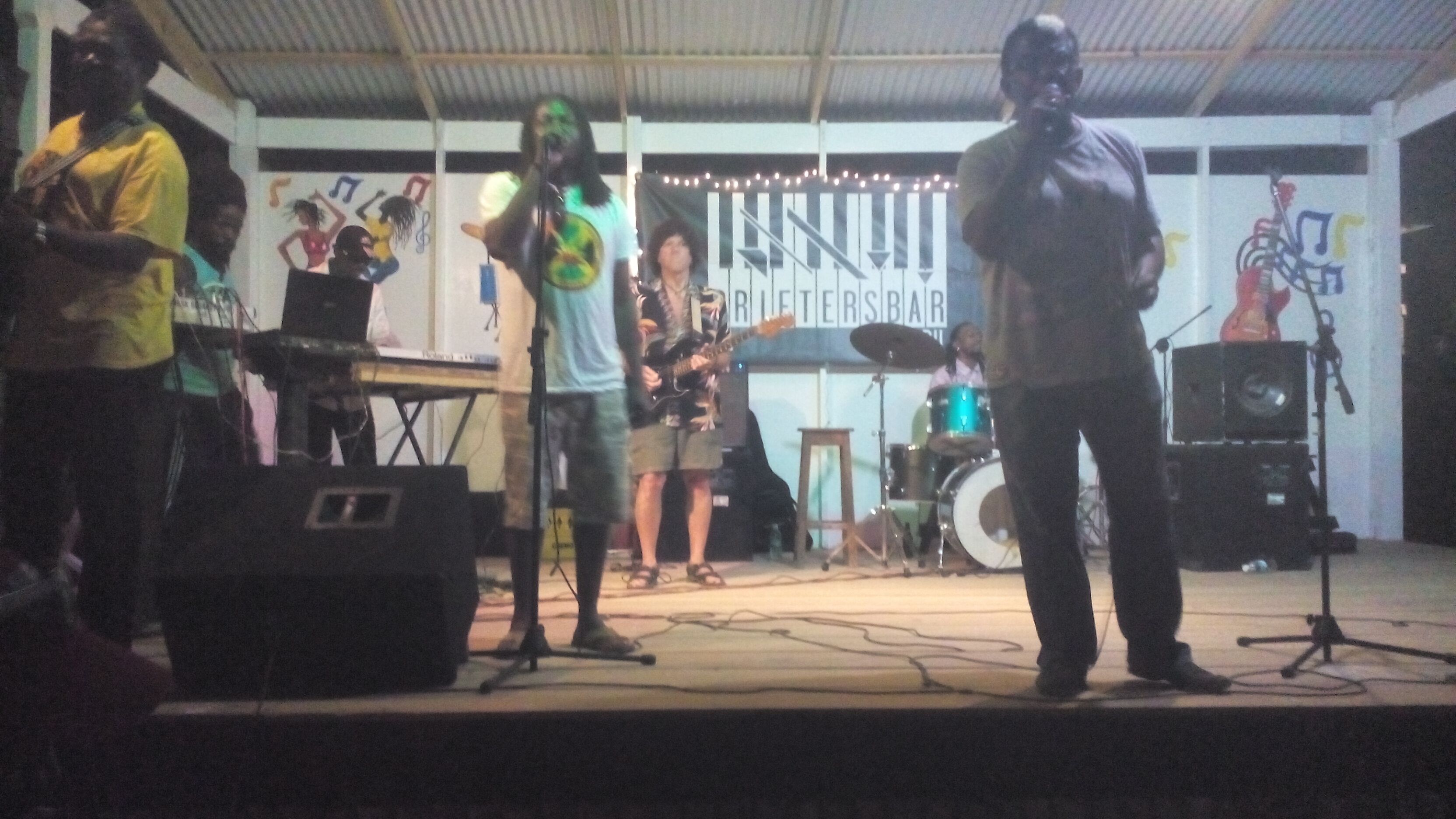 A band performing on a stage with musical instruments and a drum set.