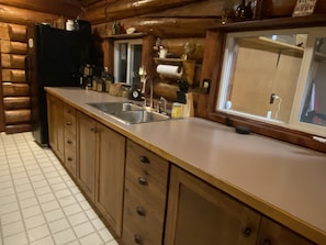 Enjoy cooking in this well-equipped kitchen with a refrigerator, sink, and ample counter space.