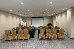 A conference room with rows of tables and chairs, a projector screen, and a whiteboard. - Jinjiang Inn Select (Qingdao International Exhibition Center Miaoling Road) (Qingdao)