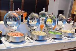 A buffet setup with various food items in metal containers. - Jinjiang Inn Select (Qingdao International Exhibition Center Miaoling Road) (Qingdao)