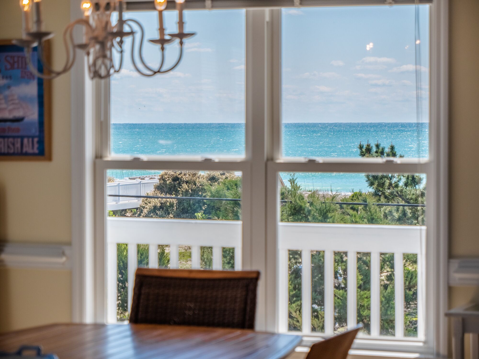 A dining area with a view of the ocean through large windows.
