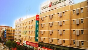 A multi-story building with signage for JINJANGINN and other businesses. - Jinjiang Inn (Changchun Railway Station) (Changchun)