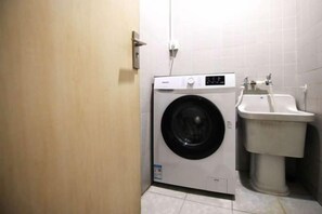 A compact laundry room with a washing machine and a sink.