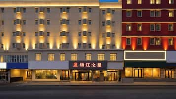 A hotel with multiple floors, a prominent entrance, and a well-lit facade.