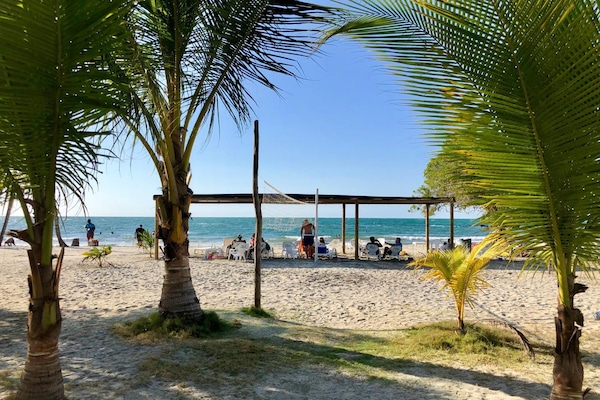 Na praia, areia branca, toalhas de praia, prática de vôlei de praia