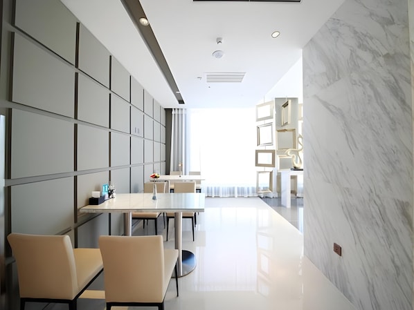 A modern interior with a long dining table, chairs, and a marble wall. - Jinjiang Inn Select (Beijing Wukesong) (Beijing)