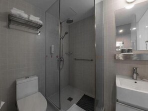 A modern bathroom with a glass shower enclosure, a toilet, and a sink with a mirror above it. - Jinjiang Inn Select (Beijing Wukesong) (Beijing)