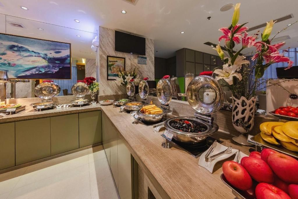 A buffet with various food items and a television mounted on the wall.