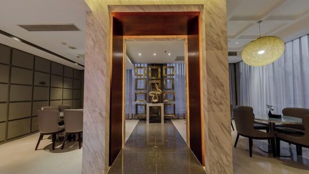 A modern hotel lobby with a marble floor, a central reception desk, and a dining area with chairs and tables. - Jinjiang Inn Select (Beijing Wukesong) (Beijing)