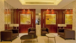 A modern lobby with a marble floor, two sofas, a coffee table, and artwork on the walls. - Jinjiang Inn Select (Beijing Wukesong) (Beijing)