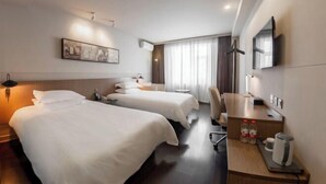 A hotel room with two beds, a desk with a chair, a television, and a painting on the wall. - Jinjiang Inn Select (Beijing Wukesong) (Beijing)