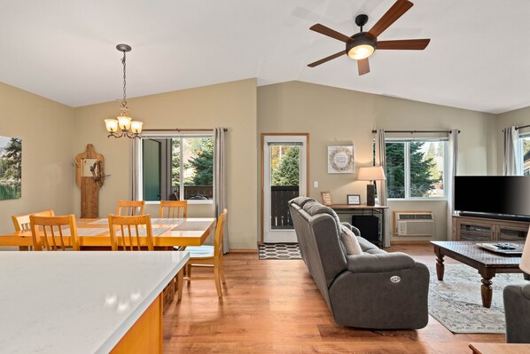 A spacious living area with a dining table, sofa, and TV.