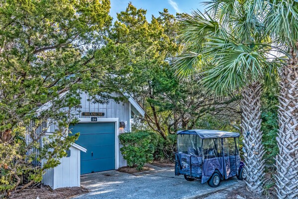 A building with a blue door labeled "SEA AND SEA" and a golf cart parked in front.