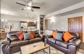 Relax in this stylish living room with a comfortable sofa, coffee table, and kitchen area.
