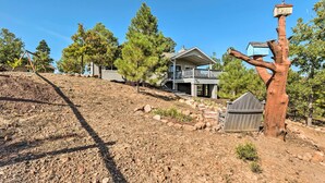A two-story house with a balcony, surrounded by trees and a rocky landscape. - Majestic Views & Wraparound Deck: Show Low Haven (Show Low)