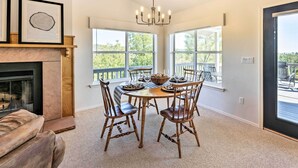 A dining area with a round table, six wooden chairs, a chandelier, and a fireplace. - Majestic Views & Wraparound Deck: Show Low Haven (Show Low)