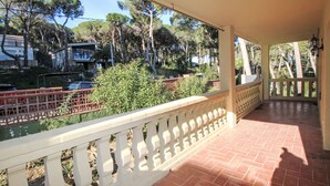 A covered outdoor area with a tiled floor and a white balustrade.