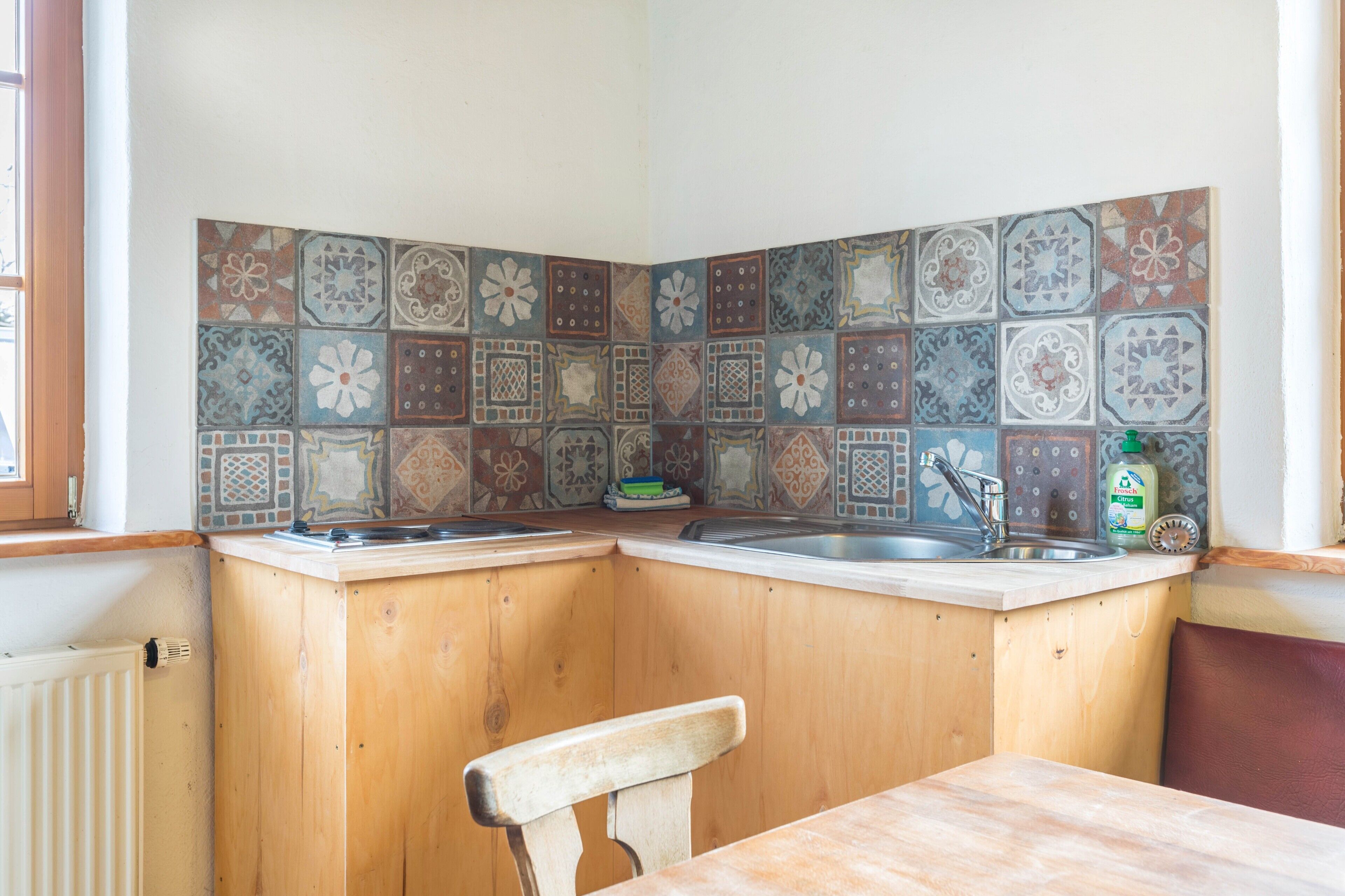 Una cucina con mobili in legno, un lavello e uno schienale piastrellato.