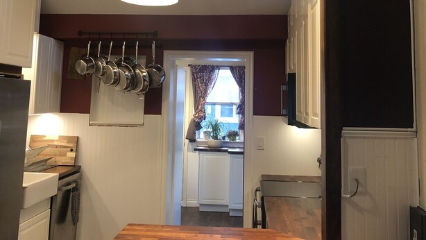 A kitchen with a wooden countertop, hanging pots, and a ceiling light fixture. - Pet friendly Bungalow. Close to Downtown and Mountains! (Lakewood)