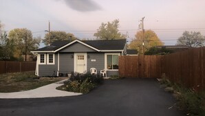 A single-story house with a front porch, a driveway, and a wooden fence. - Pet friendly Bungalow. Close to Downtown and Mountains! (Lakewood)