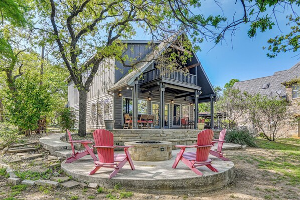 A cabin with a porch, outdoor seating, and a fire pit.