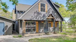 A log cabin with a gabled roof, a front porch, and a garage. - Lakefront Chico Haven w/ Multi-Level Private Dock! (Chico)
