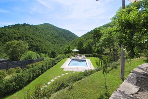 A swimming pool with a view of a forested mountain range.
