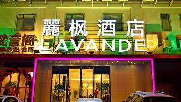 A hotel with a prominent sign reading 'LAVANDE' and a modern facade with large windows and a neon sign.