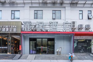 A building with a large entrance, multiple air conditioning units, and a sign with Chinese characters. - Lavande Hotel (Wuhan)