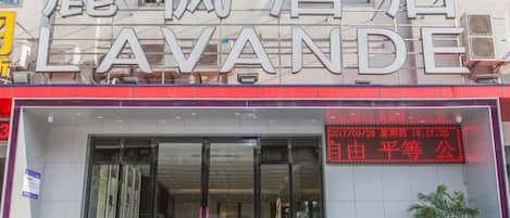 Hotel amb un gran rètol que diu 'LAVANDE' i una pantalla digital que mostra la data i l'hora.