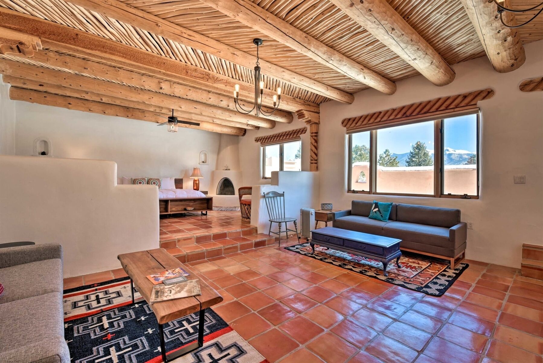 A spacious living area with a high wooden ceiling, a fireplace, a sofa, and a coffee table.