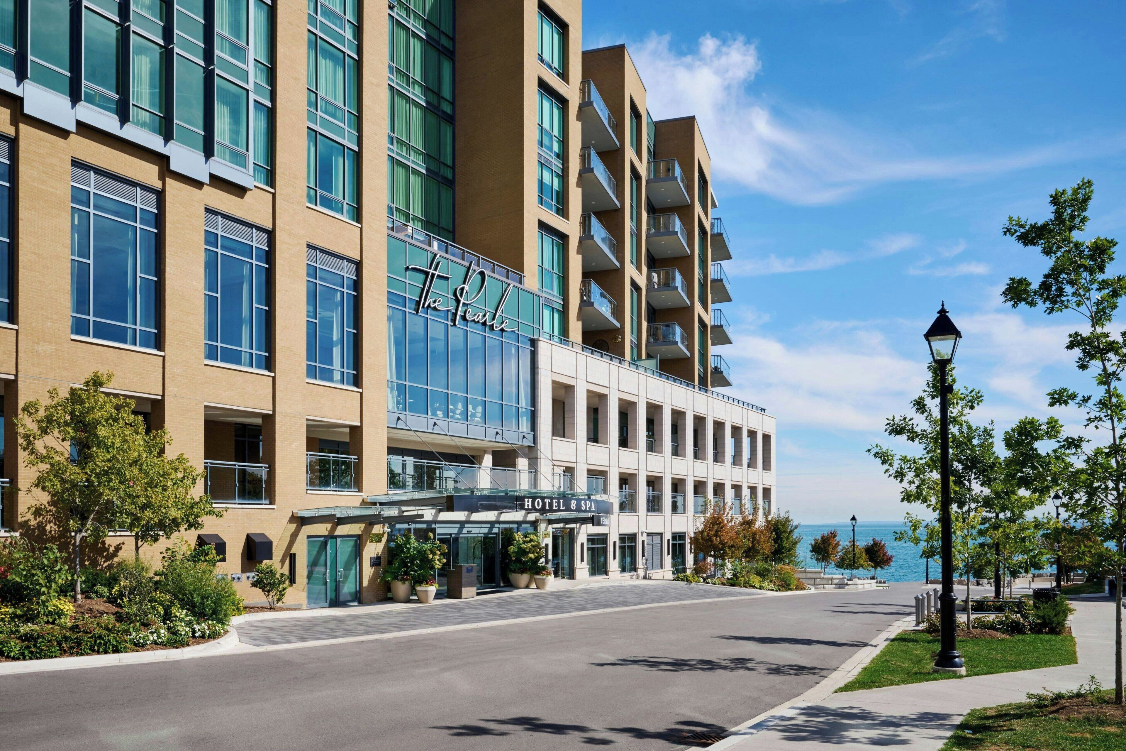 A hotel with a modern design, featuring a glass facade and multiple balconies.