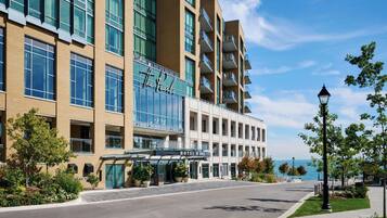 A hotel with a modern design, featuring a glass facade and multiple balconies.