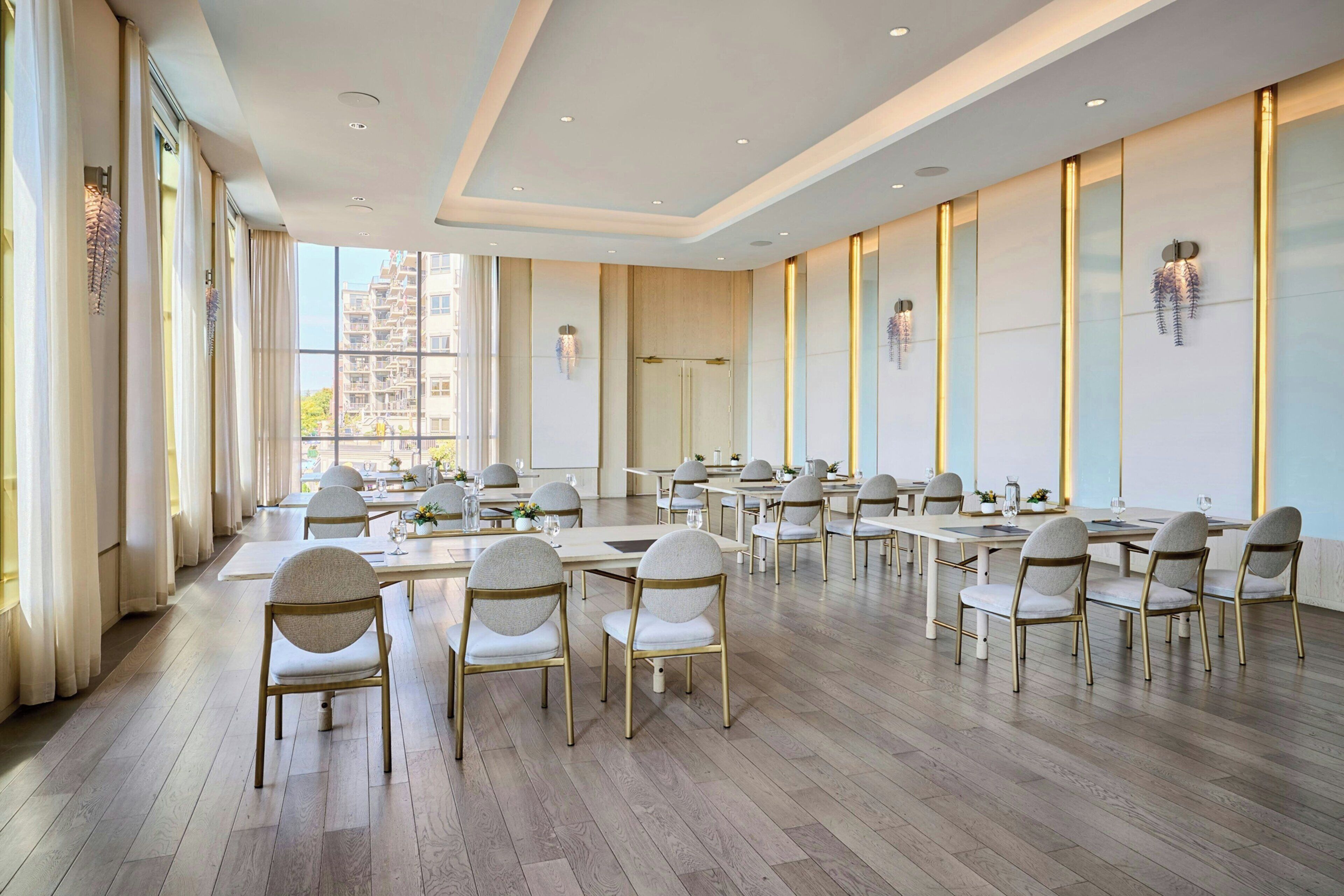 Un amplio comedor con varias mesas y sillas, ventanas grandes y un diseño de interiores moderno.