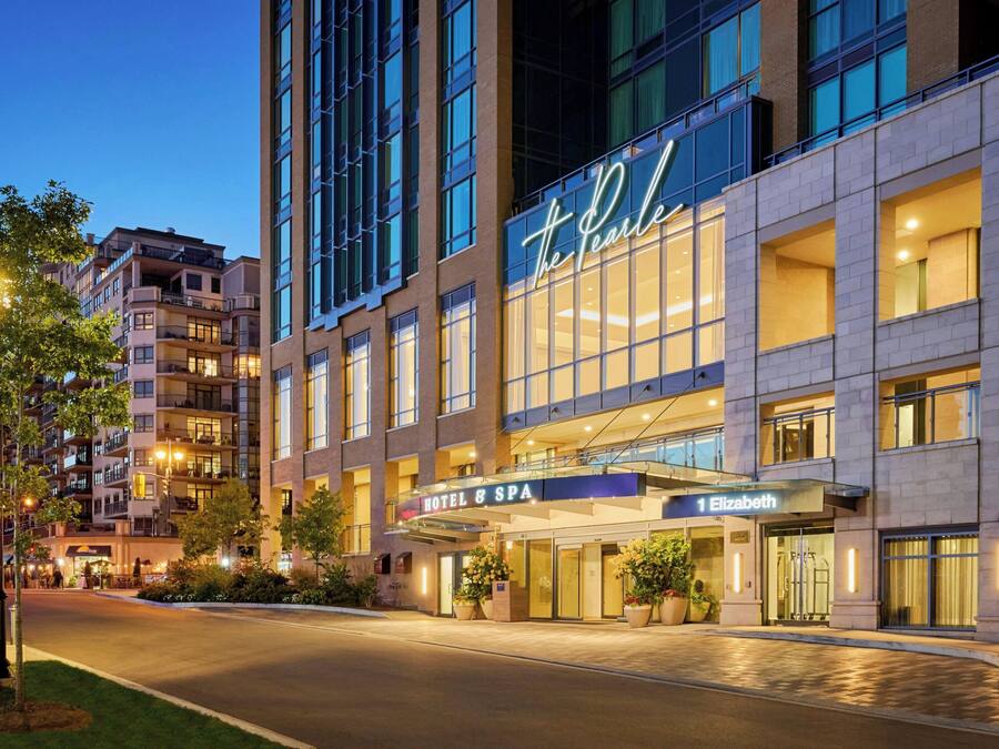 A hotel with a modern facade, multiple balconies, and a prominent sign for 'The Pearl' hotel & spa.