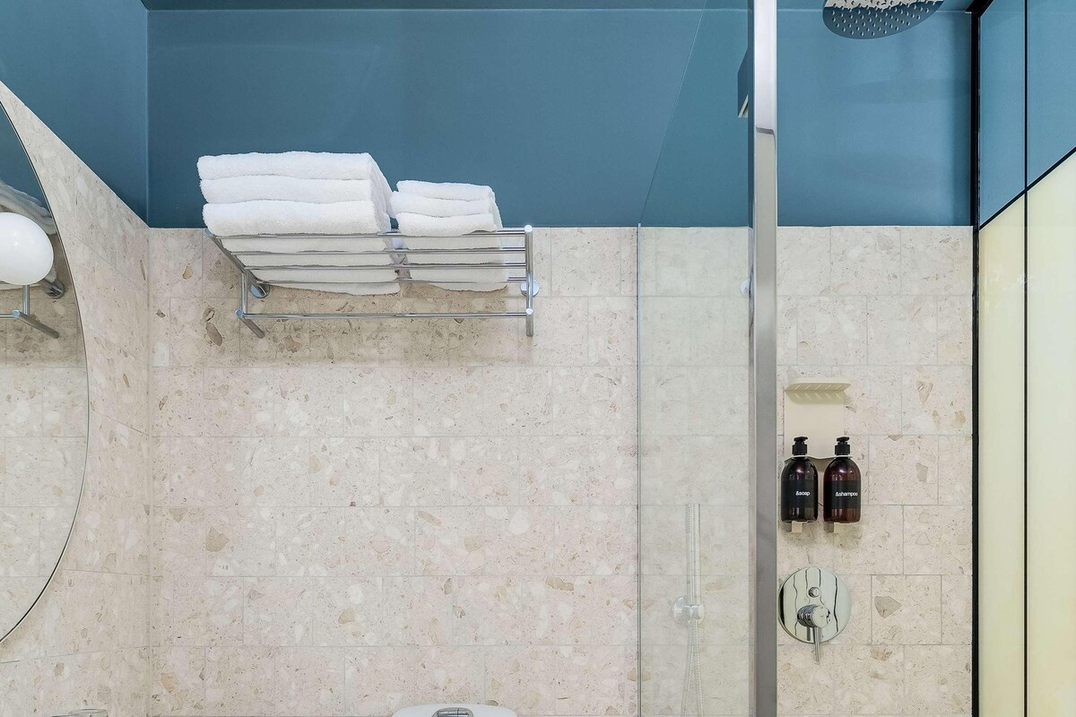 Un baño moderno con inodoro, lavamanos y ducha.