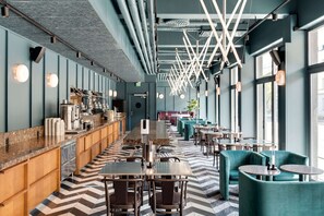 Un restaurante moderno con una barra larga, zona de estar y amplios ventanales.