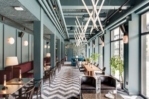 Un interior moderno con una larga zona de comedor, arreglos de asientos y una planta central.