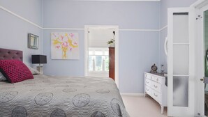 Un dormitorio con cama, cómoda y un cuadro en la pared.