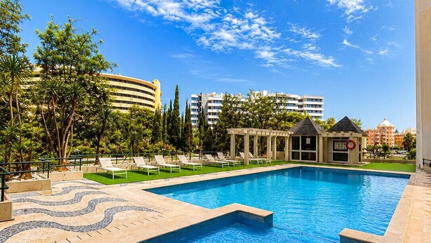 A swimming pool with a tiled deck, lounge chairs, and a pavilion. - Tália XI - Near the beach - Vilamoura (Vilamoura)