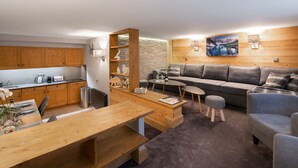 Una cocina moderna con armarios de madera, una mesa de comedor y una zona de estar acogedora con sofá y mesa de centro.
