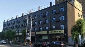 A multi-story building with a dark facade, multiple balconies, and a sign indicating a business or commercial use. - Greentree Inn Jinzhong Yuci Old Town (Jinzhong)